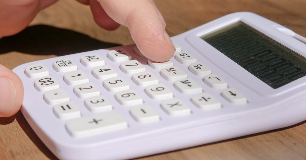 Person using a calculator to work out loan payments